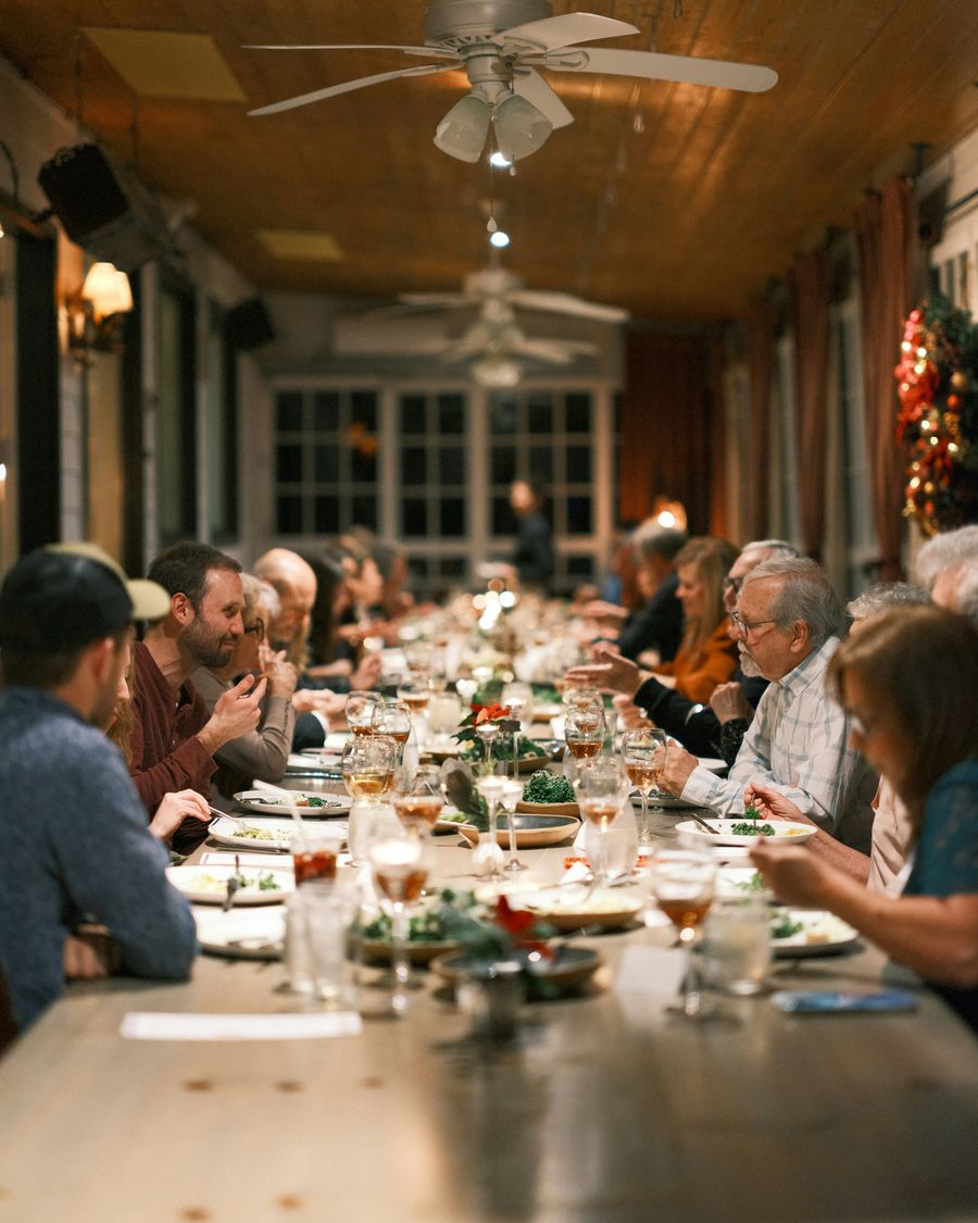 Three generations of a family sharing dinner around a long table.
